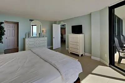 a bedroom with a large bed and a television at Edgewater Tower I 1010 in Panama City Beach