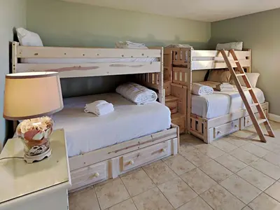 two bunk beds in a room with a lamp and a table at Edgewater Tower I 1010 in Panama City Beach