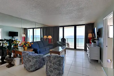 a living room with a blue couch and a view of the ocean at Edgewater Tower I 1010 in Panama City Beach