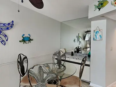 a dining room with a glass table and chairs at Edgewater Tower II in Panama City Beach
