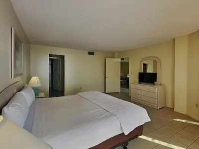 a bedroom with a large white bed and a television at Edgewater Tower II 110 in Panama City Beach