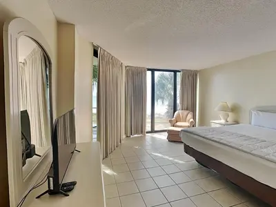 a bedroom with a bed and a tv in a room at Edgewater Tower II 110 in Panama City Beach