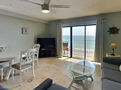 a living room with a table and a view of the ocean at Summit Beach Resort #915 in Panama City Beach