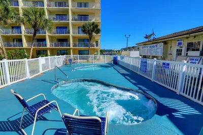 a hot tub with two chairs and a hotel at Summit Beach Resort 1230 in Panama City Beach