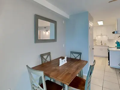 a kitchen and dining room with a wooden table and chairs at Summit Beach Resort 1230 in Panama City Beach