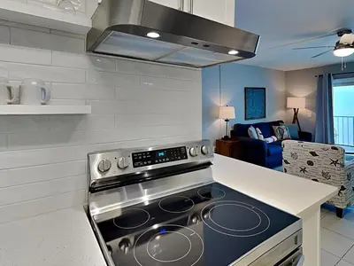 a kitchen with a stove top oven next to a living room at Summit Beach Resort 1230 in Panama City Beach