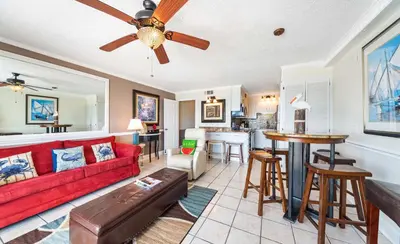 a living room with a red couch and a kitchen at Summit Beach Resort #821 in Panama City Beach