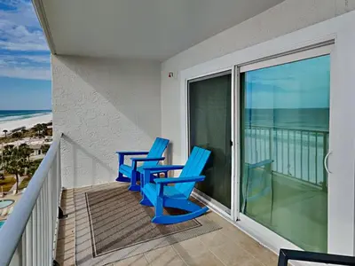 two blue chairs on a balcony with a view of the ocean at Summit Beach Resort #821 in Panama City Beach