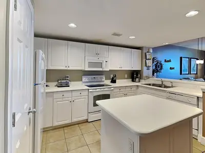 a kitchen with white cabinets and a white refrigerator at Majestic Beach Towers II #2005 in Panama City Beach