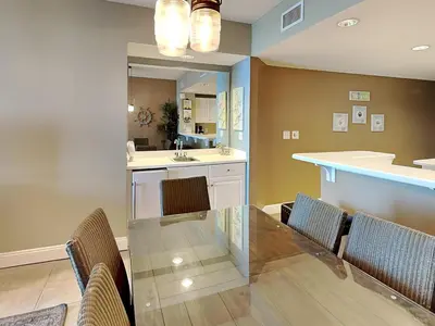 a dining room with a table and chairs and a mirror at Majestic Beach Towers II #2005 in Panama City Beach