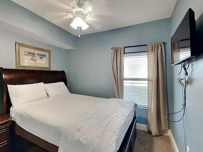 a bedroom with a bed and a flat screen tv at Majestic Beach Towers II #2005 in Panama City Beach