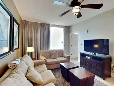a living room with a couch and a flat screen tv at Majestic Beach Towers II #2005 in Panama City Beach