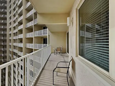 a balcony of a building with a chair and shelves at Shores of Panama #1111 in Panama City Beach