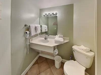 a bathroom with a toilet and a sink and a mirror at Shores of Panama #1510 in Panama City Beach