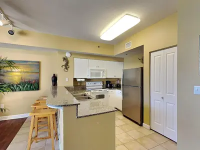a kitchen with white cabinets and a counter top at Shores of Panama #1908 in Panama City Beach