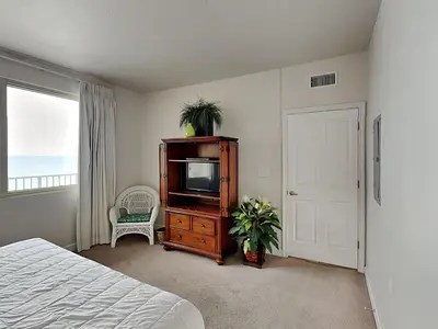 a bedroom with a tv on a dresser and a door at Shores of Panama #1611 in Panama City Beach