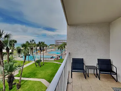 a balcony with two chairs and a view of a pool at Summit Beach Resort 330 in Panama City Beach