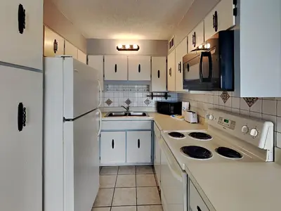 a kitchen with white appliances and a white refrigerator at Summit Beach Resort 330 in Panama City Beach