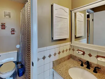 a bathroom with a sink and a toilet and a mirror at Summit Beach Resort 330 in Panama City Beach