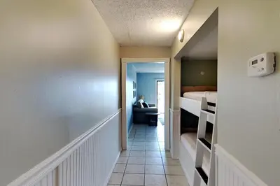 a hallway leading to a room with a bed and a bedroom at Summit Beach Resort 330 in Panama City Beach