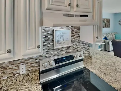a kitchen with white cabinets and a stove top oven at Summit Beach Resort #326 in Panama City Beach