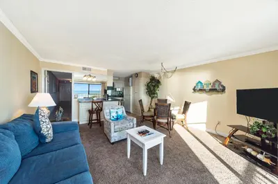 a living room with a blue couch and a table at Summit Beach Resort #429 in Panama City Beach