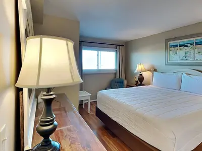 a bedroom with a bed with a lamp and a window at Summit Beach Resort #429 in Panama City Beach