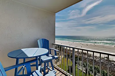 a balcony with a table and chairs and the beach at Summit Beach Resort 604 in Panama City Beach