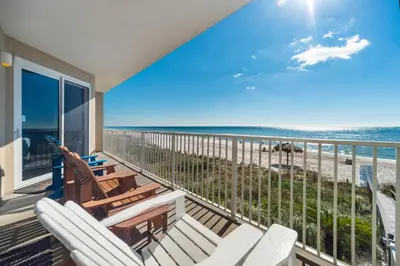 a balcony with chairs and a view of the beach at Grandview East #104 in Panama City Beach