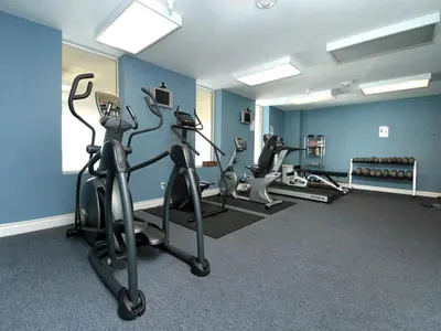 a gym with treadmills and ellipticals in a room at Grandview East #104 in Panama City Beach