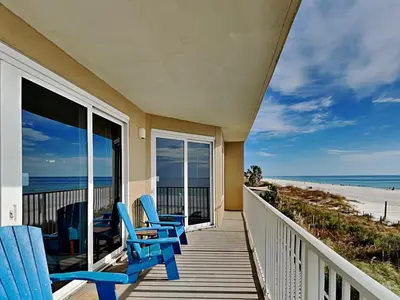 a porch with two blue chairs and the beach at Grandview East #104 in Panama City Beach