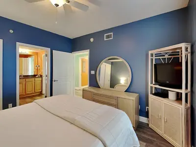 a bedroom with a bed and a mirror and a tv at Grandview East #104 in Panama City Beach