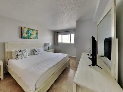 a bedroom with a large bed and a flat screen tv at Summit Beach Resort #526 in Panama City Beach