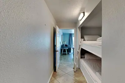 a small room with a bunk bed and a hallway at Summit Beach Resort #526 in Panama City Beach