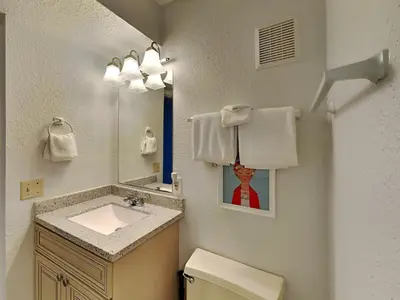 a bathroom with a sink and a toilet and a mirror at Summit Beach Resort #526 in Panama City Beach