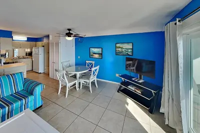 a living room with a table and a blue wall at Summit Beach Resort in Panama City Beach