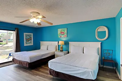 two beds in a bedroom with blue walls at Edgewater Villa 1001 in Panama City Beach