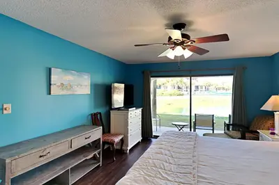 a bedroom with a bed and a ceiling fan at Edgewater Villa 1001 in Panama City Beach