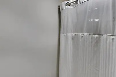 a white shower curtain next to a wall at Edgewater Villa 1001 in Panama City Beach