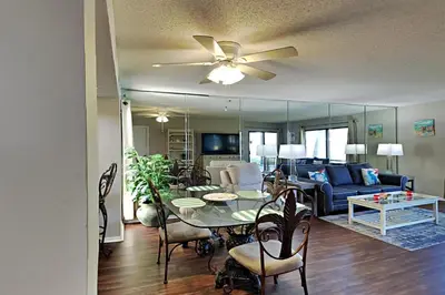 a living room with a dining table and a couch at Edgewater Villa 1001 in Panama City Beach