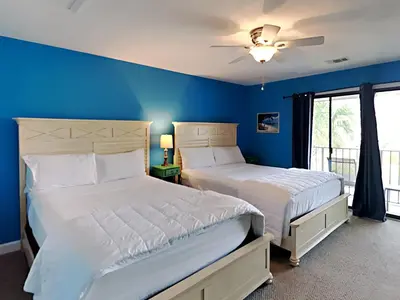 two beds in a bedroom with blue walls at Edgewater Villa 1312 in Panama City Beach