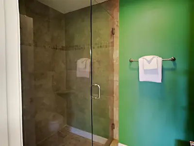 a shower with a glass door with towels on it at Edgewater Villa 1312 in Panama City Beach