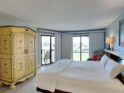 a bedroom with a large bed with a yellow dresser at Edgewater Villa 1211 in Panama City Beach
