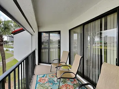 a balcony with two chairs and a rug at Edgewater Villa 1211 in Panama City Beach