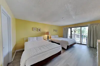 a hotel room with two beds and a balcony at Edgewater Villa 1410 in Panama City Beach