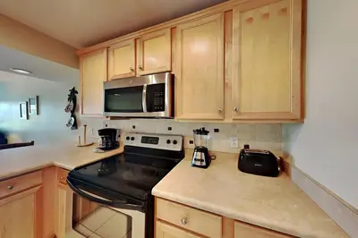 a kitchen with a stove and a microwave at Edgewater Villa 1410 in Panama City Beach
