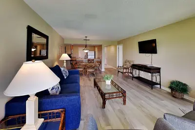 a living room with a blue couch and a table at Edgewater Villa 1410 in Panama City Beach