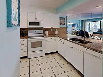 a kitchen with white cabinets and a sink at Edgewater Villa 1509 in Panama City Beach
