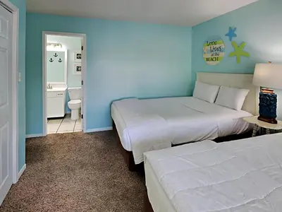 a hotel room with two beds and a bathroom at Edgewater Villa 1509 in Panama City Beach