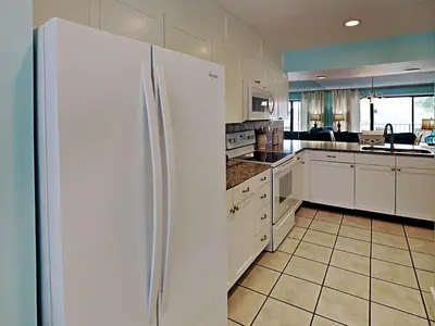 a kitchen with white appliances and a white refrigerator at Edgewater Villa 1509 in Panama City Beach